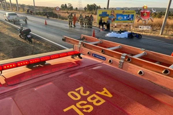 Moto coberta por pano branco, enquanto bombeiros fazem resguardo de rodovia - Metrópoles