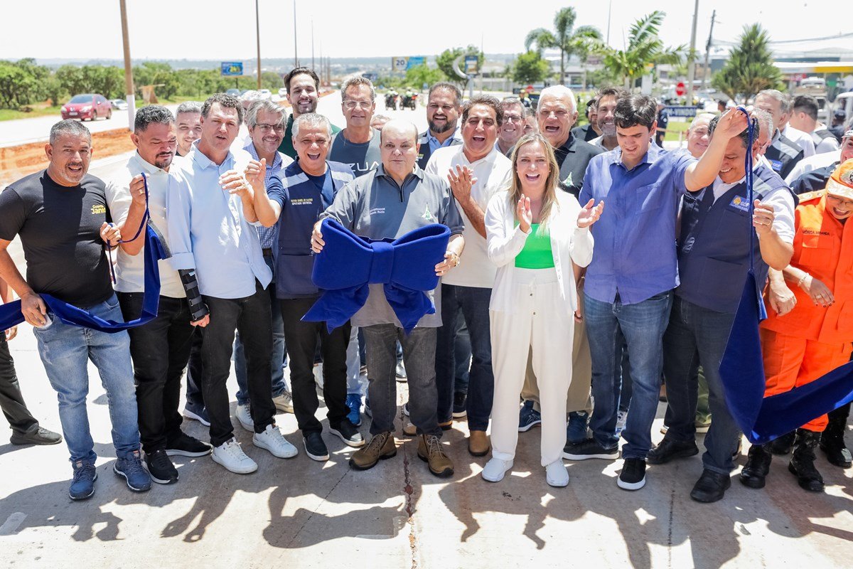 Fotografia colorida de grupo de políticos com laço de inauguração de obra nas mãos