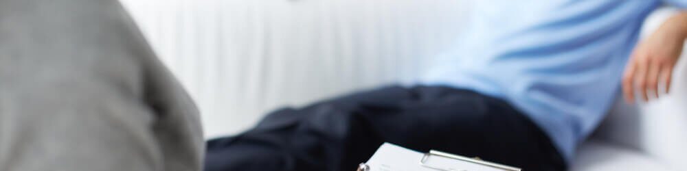 Imagem colorida de homem sentado no sofá enquanto alguém anota o que ele diz - Metrópoles