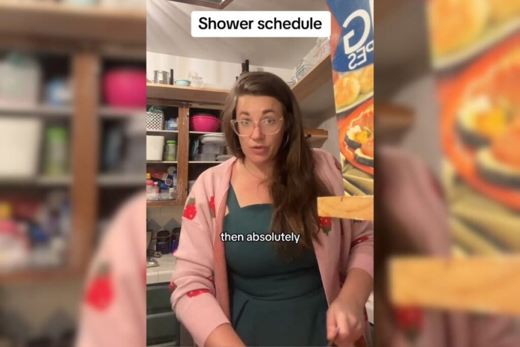 Imagem colorida de mulher olhando para a câmera enquanto cozinha - Metrópoles