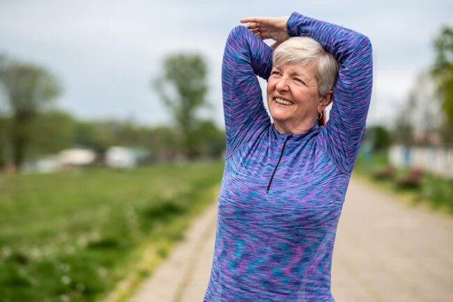 Mulher mais velha pratica e alongamento no parque