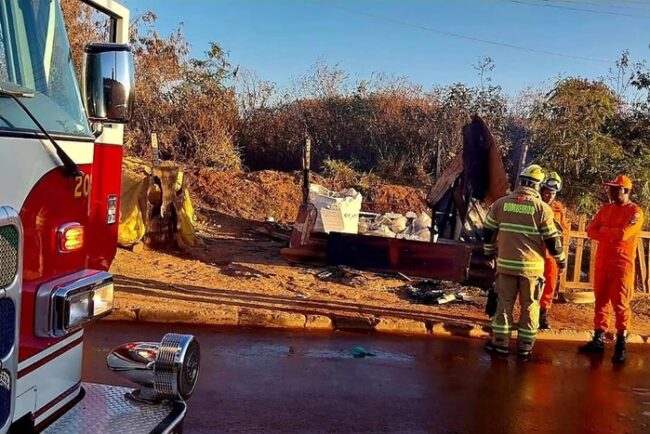 Foto colorida de edificação precária de madeira atingida por incêndio
