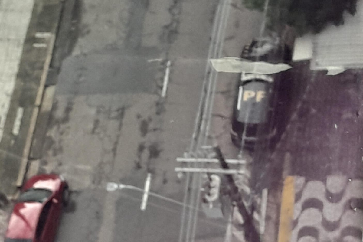 Imagem colorida de uma rua com um carro da Polícia Federal estacionado - Metrópoles