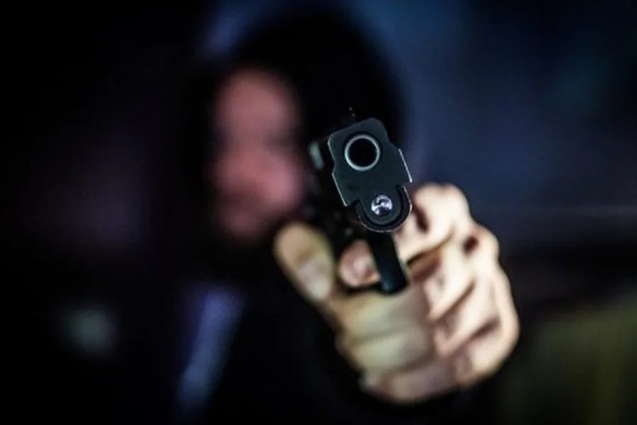 Imagem colorida mostra homem armado - Metrópoles