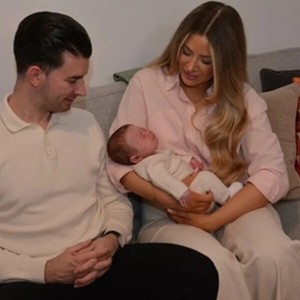 Foto colorida de familia com bebê recém-nascido no colo, resultad de transplante de útero em sucedido - Metrópoles.